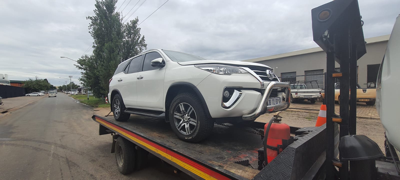 white toyota fortuner loaded on nyati's towtruck